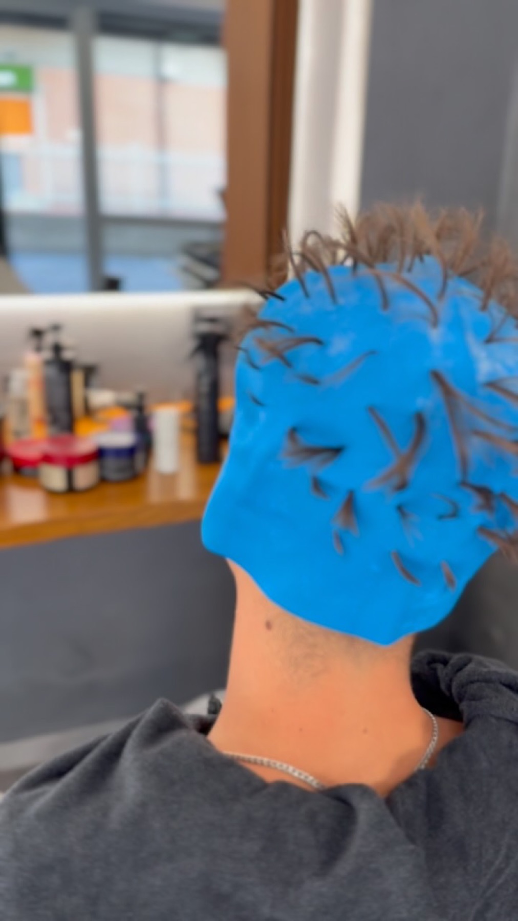 Cliente con cuffia blu durante una lavorazione di mèches in salone