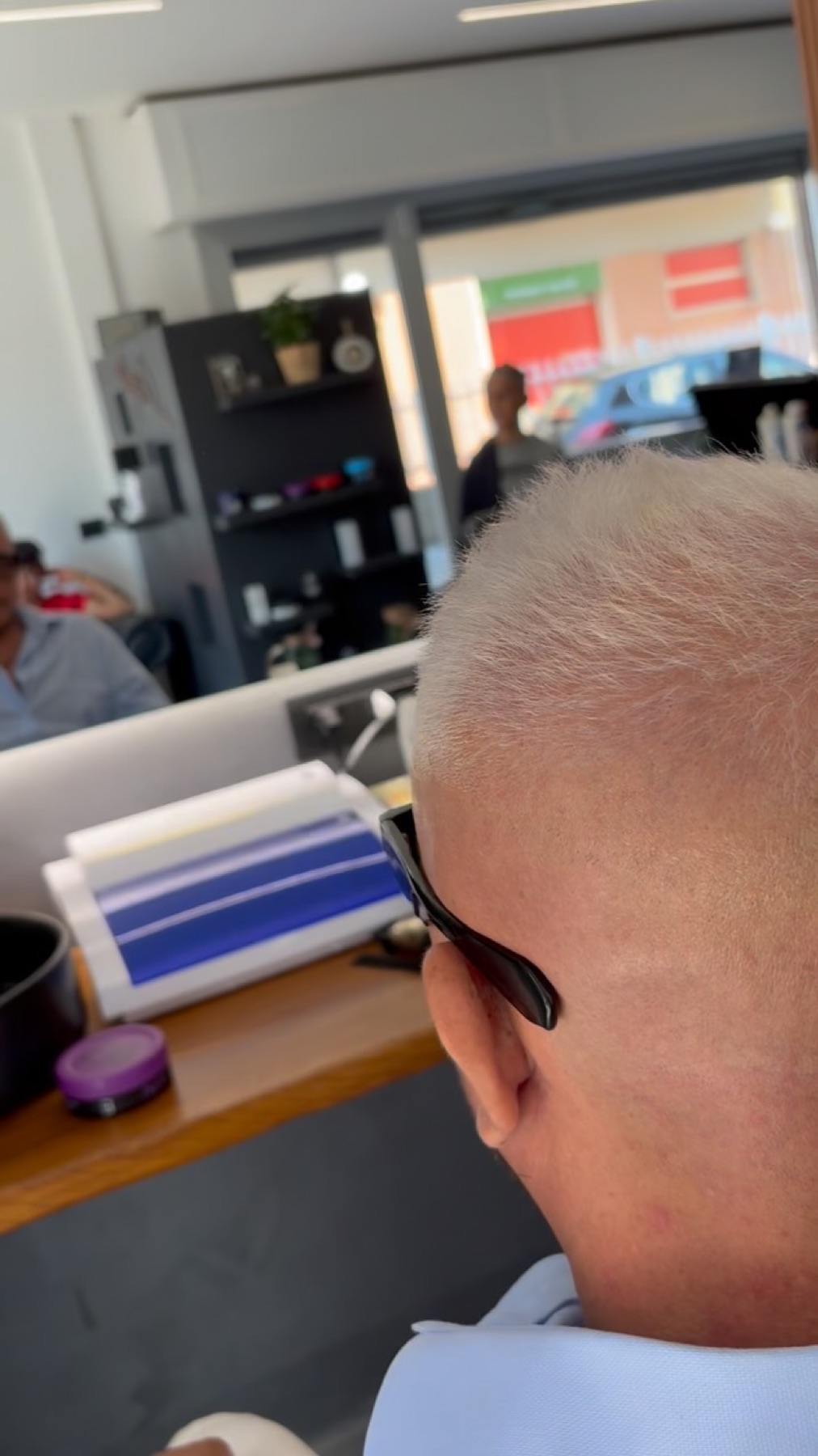 Vista posteriore di un taglio molto corto con capelli bianchi appena lavorati